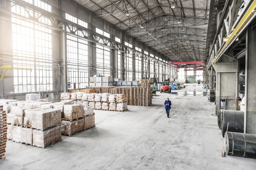 Manager walking through factory warehouse