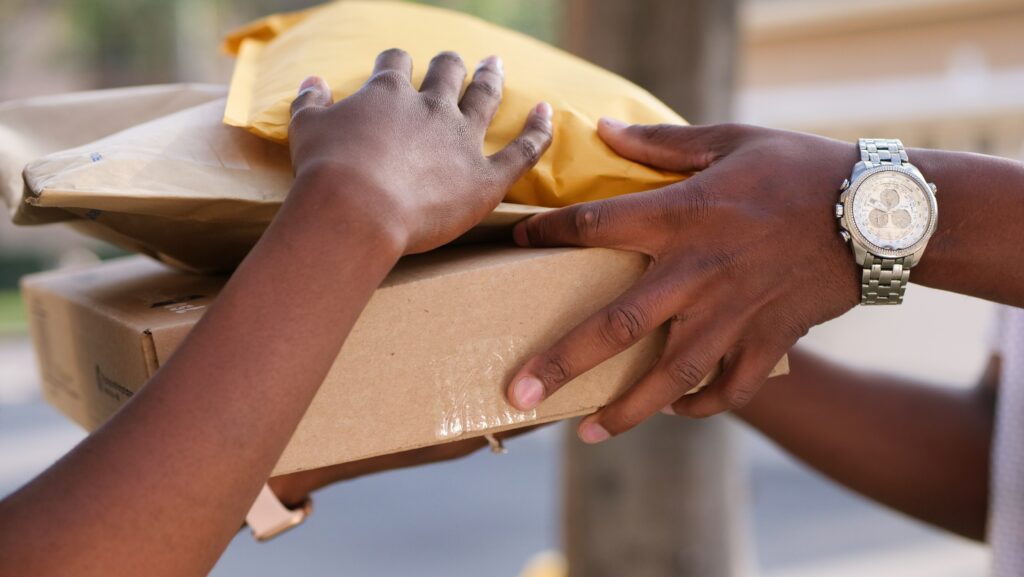 Person handing three packages to another person